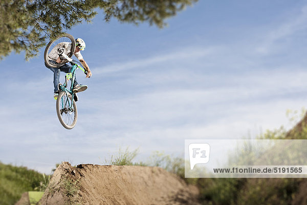 Dirt biker doing tricks during jump
