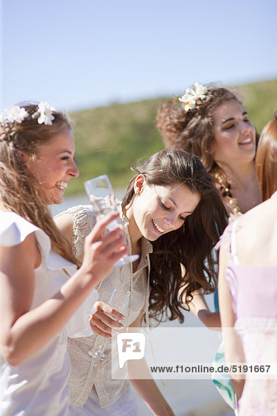 Bride drinking champagne with friends