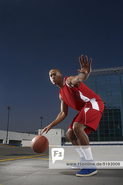 Basketballspieler beim Dribbeln auf dem Dach
