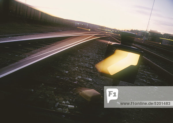 Bahngleise und Leuchtpfeil  Sonnenuntergang
