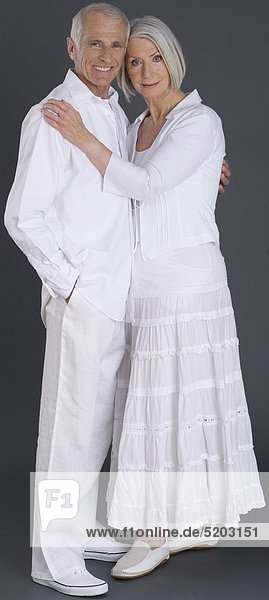 Seniorenpaar  weiß gekleidet  umarmt