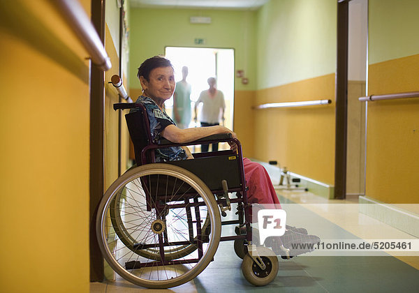 Altenheim  Seniorin sitzt am Gang in Rollstuhl