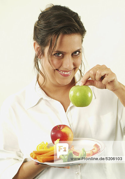 Frau mit Obst und Gemüse auf Teller
