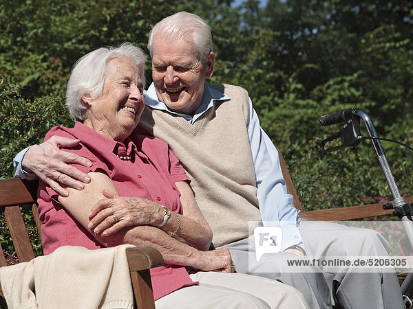Seniorenpaar  sitzen auf Parkbank  lachen