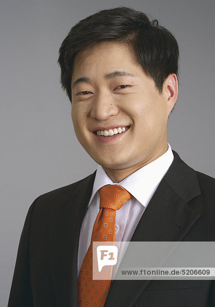 Mann  asiatisch  im Anzug  lächelt  Porträt