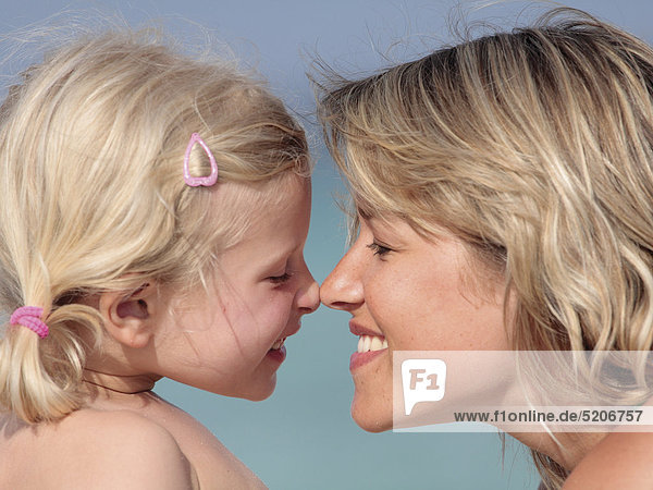 Mutter mit kleiner Tochter am Strand  Nase an Nase  Porträt