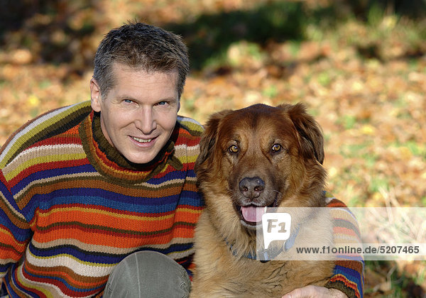 Mann mit Hund in herbstlichem Park  Halbporträt