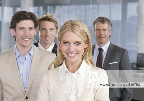 Frau und drei Männer stehen in Büro  Halbporträt