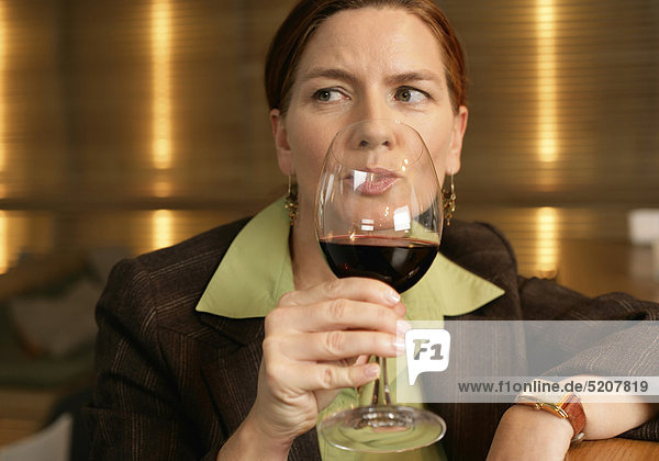 Frau trinkt an Bar Rotwein