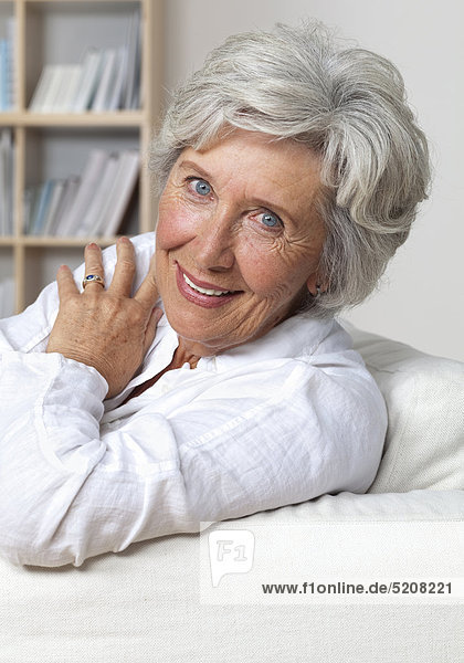 Seniorin zu Hause auf Sofa  Halbporträt
