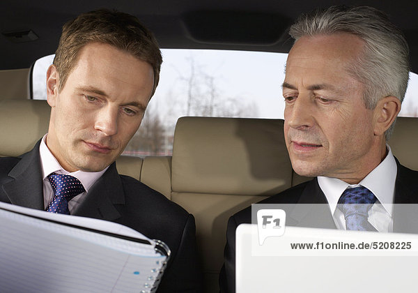 Zwei Männer im Auto  Rücksitz  Besprechung