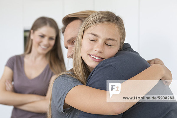Tochter umarmt Vater  Mutter im HG