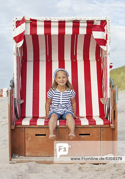 Mädchen sitzt in Strandkorb