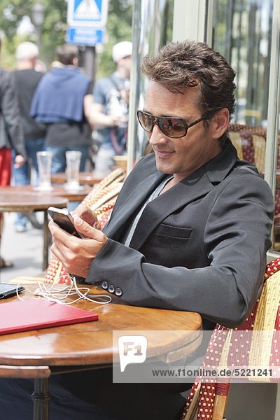 Mann mit Handy in einem Restaurant  Paris  Ile-de-France  Frankreich