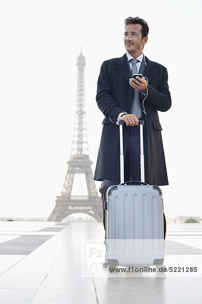 Geschäftsmann stehend mit Gepäck mit dem Eiffelturm im Hintergrund  Paris  Ile-de-France  Frankreich