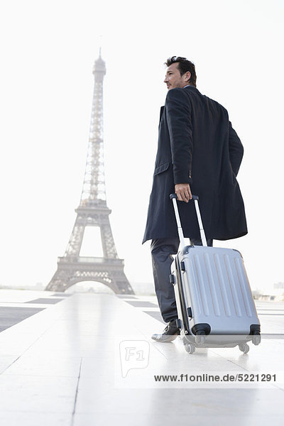 Geschäftsmann mit Gepäck und dem Eiffelturm im Hintergrund  Paris  Ile-de-France  Frankreich