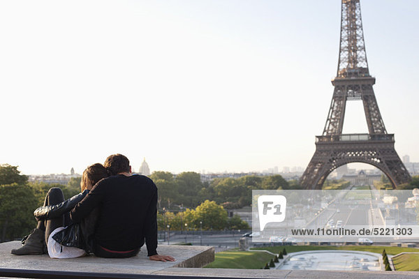 Paar sitzend zusammen mit dem Eiffelturm im Hintergrund  Jardins du Trocadero  Paris  Ile-de-France  Frankreich
