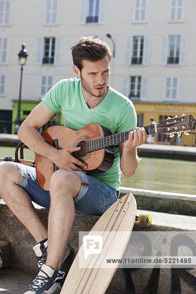 Mann spielt Gitarre  Canal St Martin  Paris  Ile-de-France  Frankreich