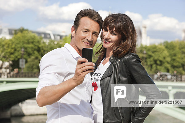 Paar fotografiert sich mit einem Handy  Seine River  Paris  Ile-de-France  Frankreich