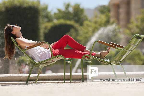 Frau auf einem Stuhl in der Nähe eines Teiches  Bassin achteckig  Jardin des Tuileries  Paris  Ile-de-France  Frankreich