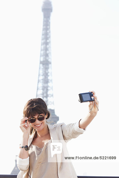 Woman taking a picture of herself with the Eiffel Tower in the background  Paris  Ile-de-France  France