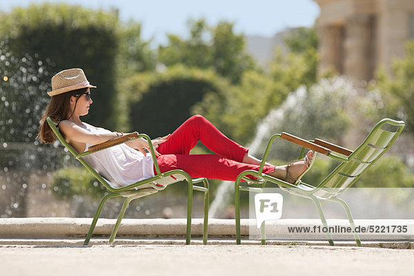 Frau auf einem Stuhl in der Nähe eines Teiches  Bassin achteckig  Jardin des Tuileries  Paris  Ile-de-France  Frankreich