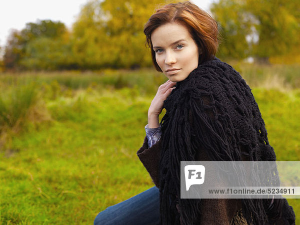 A beautiful woman wrapped in a shawl  outdoors