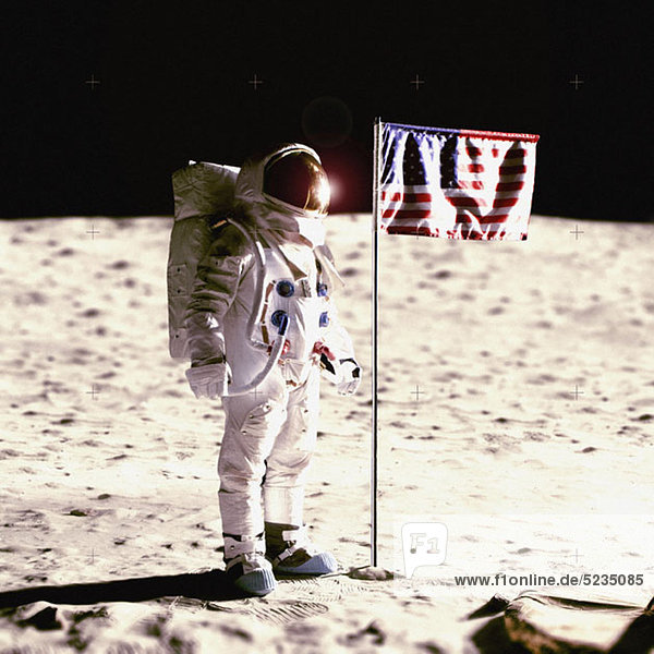 An astronaut next to an American flag on the moon