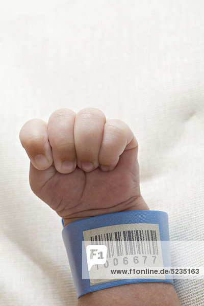 Ein Krankenhaus-Ausweis-Armband am Handgelenk eines Babys.