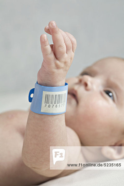 Ein Baby mit einem Krankenhaus-ID-Armband am Handgelenk.