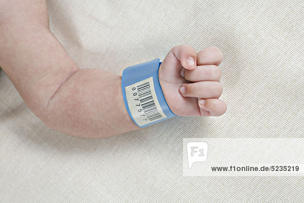 Ein Krankenhaus-Ausweis-Armband am Handgelenk eines Babys.
