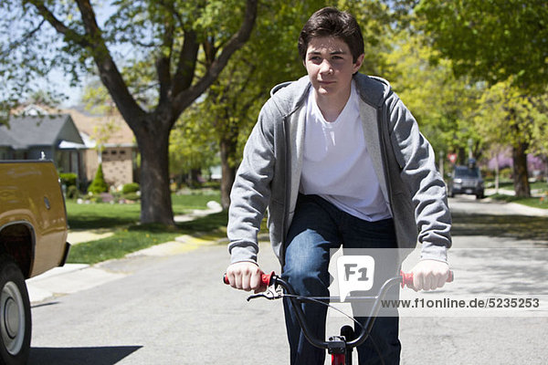 Junge steht beim Radfahren mit einem zufriedenen Gesichtsausdruck