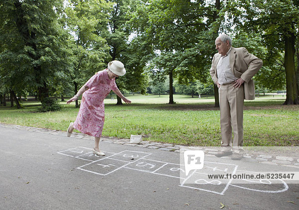 Seniorenpaar spielen Hopscotch