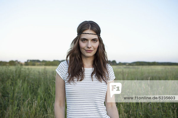 profile of girl with hair band standing in secluded field