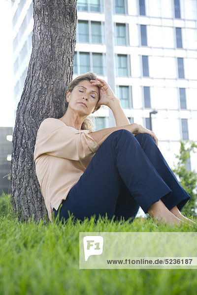 Woman sitting in grass resting