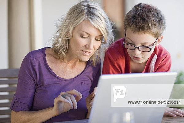 Mutter und Sohn benutzen gemeinsam einen Laptop