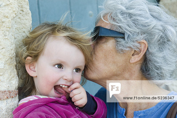 Großmutter küsst junge Enkelin