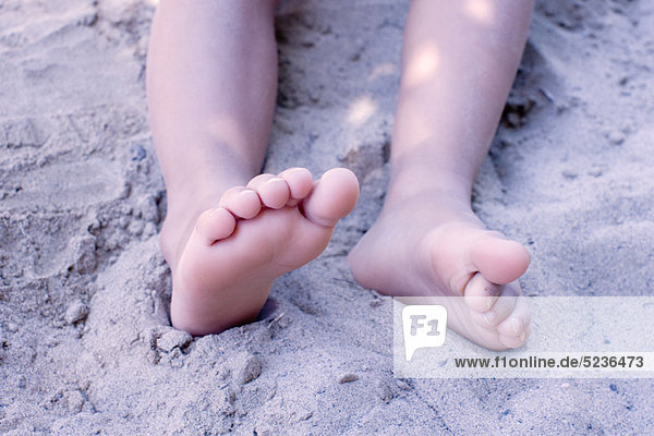 Beine des kleinen Mädchens im Sand,  niedrige Sektion