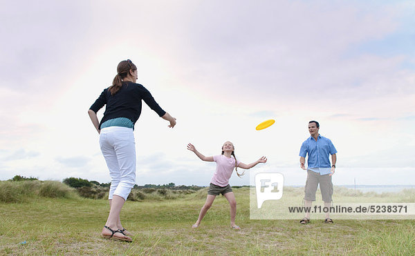 Family playing with frisbee outdoors