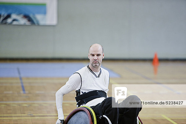 Man in wheelchair playing indoor sports