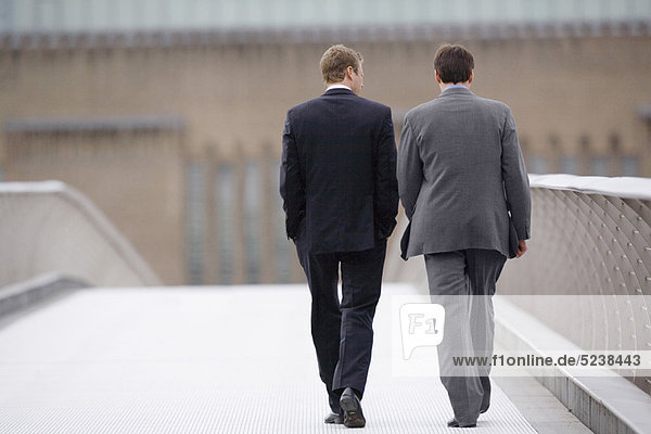 Businessmen walking on bridge together