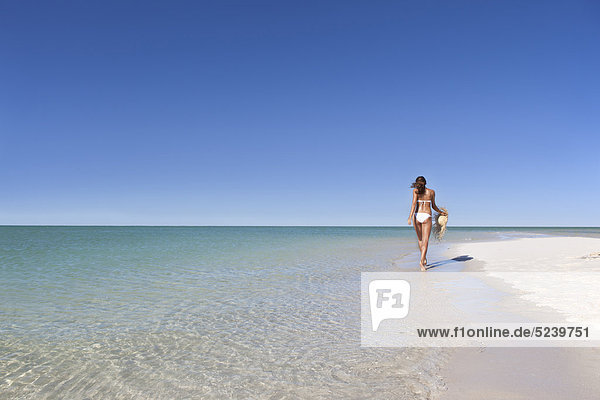 Frau die Strohhut am Strand