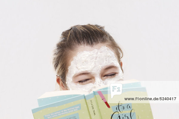 Frau mit Gesichtsmaske  hält Buch vor Gesicht