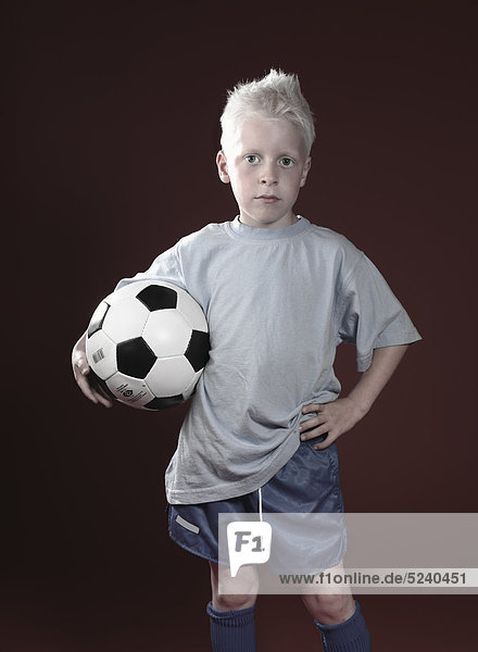 Kleiner Junge mit Fußball unter dem Arm