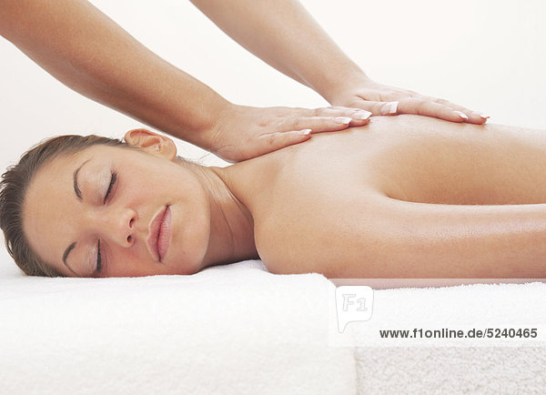 Frau liegt entspannt bei Massage-Behandlung