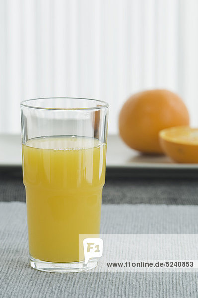 Glas Orangensaft mit Orangensaft auf dem Tisch