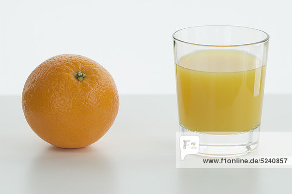 Glas Orangensaft mit Orangensaft auf dem Tisch