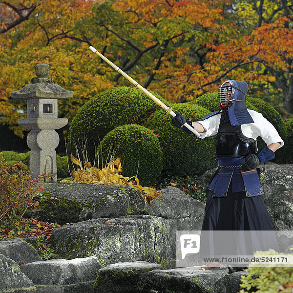 Kendo-Kämpfer in japanischem Garten