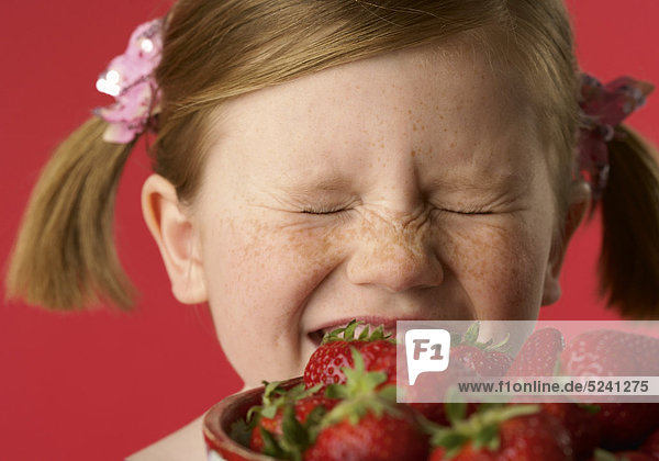 Mädchen beißt in Erdbeeren