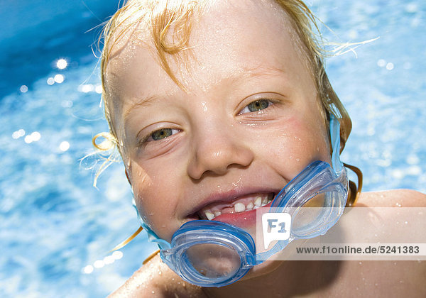Kleiner Junge an Pool  Schwimmbrille heruntergerutscht  Porträt